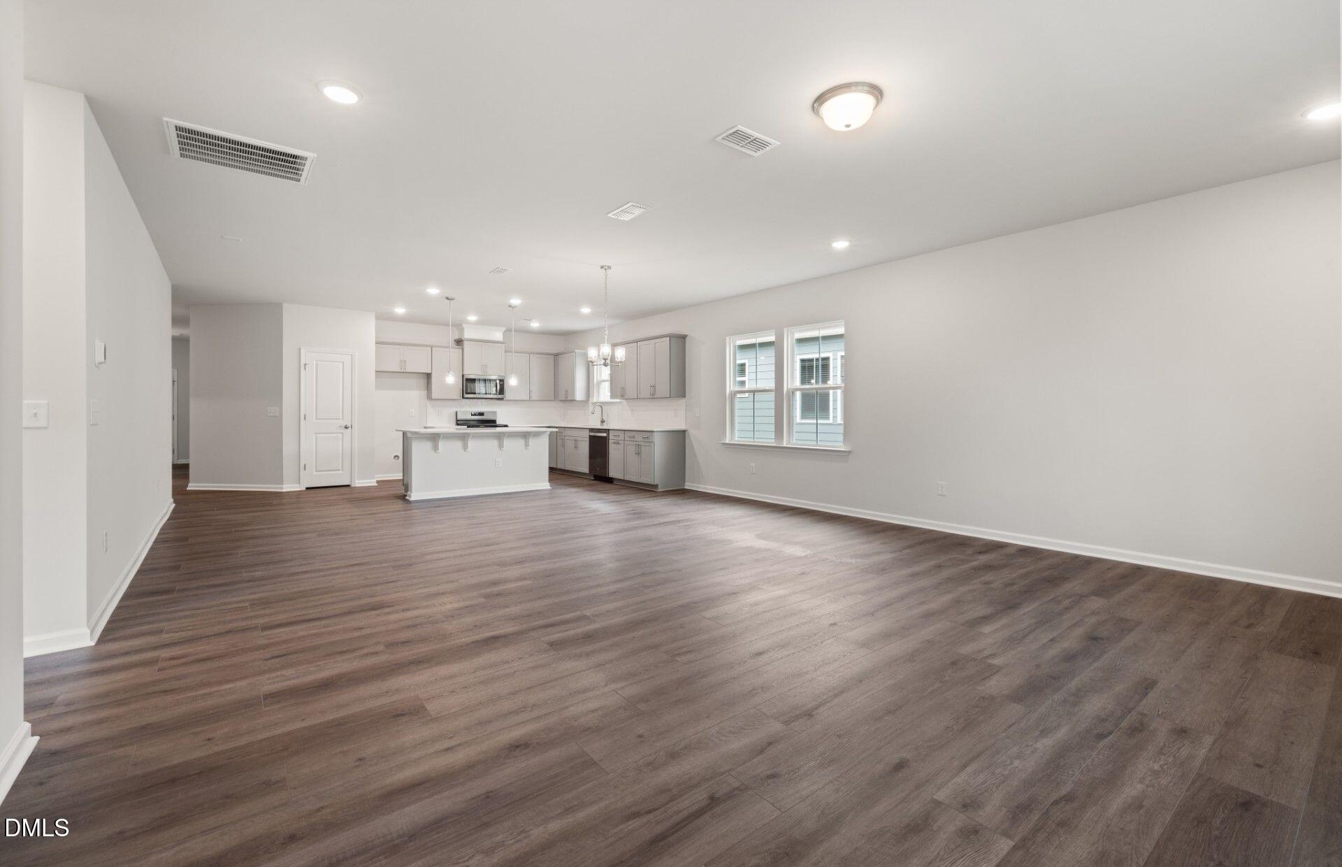 316 Broomside Avenue Raleigh, NC 27603 - Photo 8 of 31 an empty room with wooden floor and windows