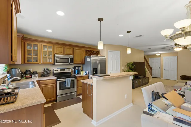 a kitchen with kitchen island a stove a sink a oven a dining table and chairs