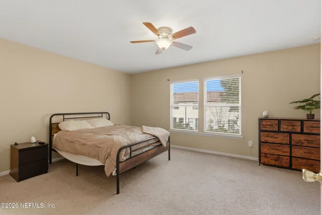 a bed sitting in a spacious bedroom next to a window