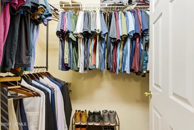 a view of walk in closet with clothes