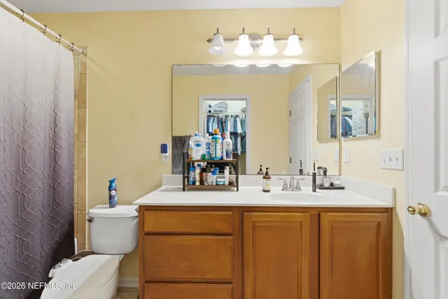a bathroom with a sink vanity mirror and toilet