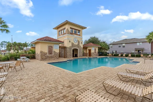 a view of a house with swimming pool and sitting area