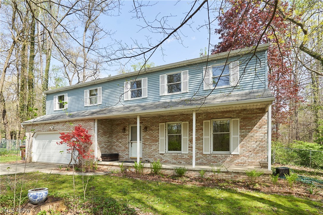 Two-story residence featuring a brick first level and blue siding second level