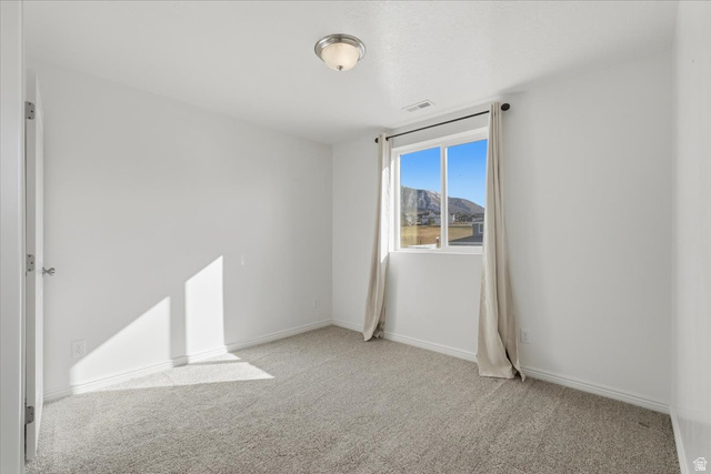 1218 Moonlight Drive Elk Ridge, UT 84651 - Photo 18 of 44 Empty room with light carpet and a mountain view