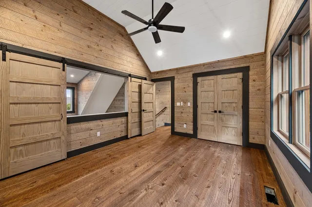 a view of room with hardwood floor and a ceiling fan
