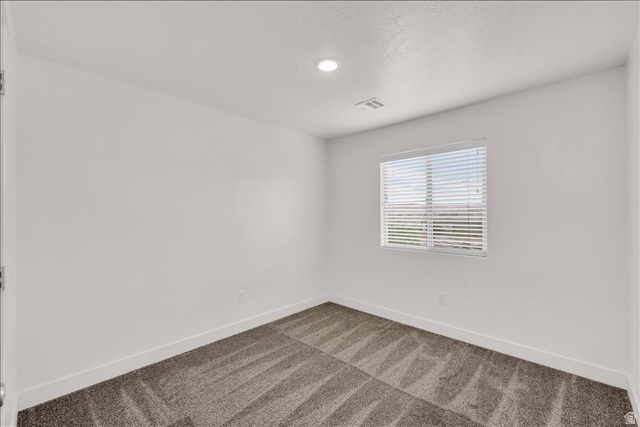 5875 Challenger Way St. George, UT 84790 - Photo 14 of 18 Bright room featuring a single window with blinds, recessed ceiling lighting, and patterned carpeting