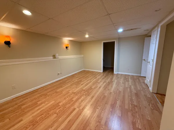 an empty room with wooden floor and entrance