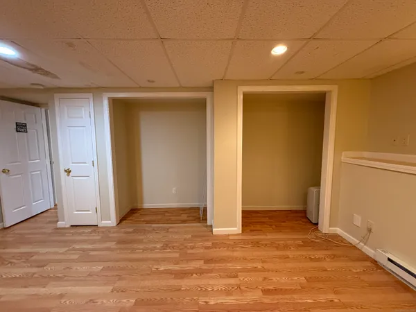 an empty room with wooden floor and natural light