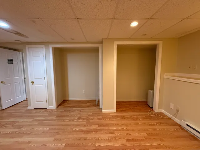 an empty room with wooden floor and natural light