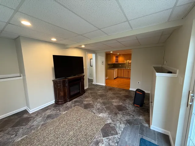 a living room with a flat screen tv and a refrigerator