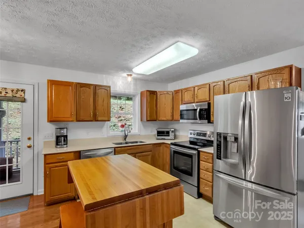 a kitchen with a sink a stove a microwave and refrigerator