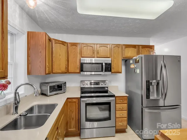 a kitchen with stainless steel appliances a sink stove and cabinets