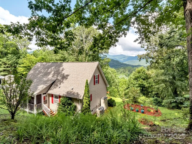 an aerial view of house with yard and mountain view in back
