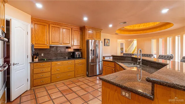 a kitchen with stainless steel appliances granite countertop a sink refrigerator and cabinets