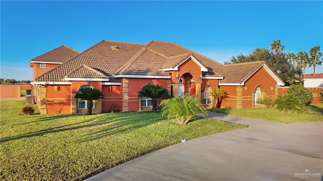 a view of a big house with a big yard and potted plants