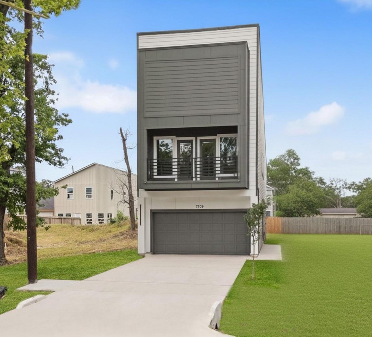 7709 Willow Street Houston, TX 77088 - Photo 1 of 15 Striking modern new construction at 7709 Willow St featuring a sleek two-tone facade, integrated two-car garage, and private upper-level balcony.