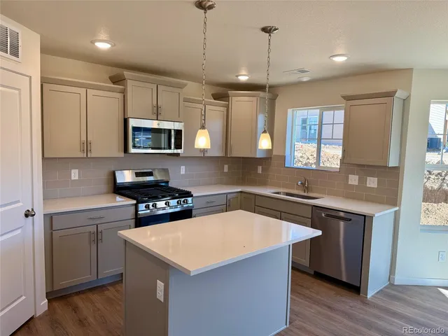 a kitchen with stainless steel appliances granite countertop a sink stove and microwave