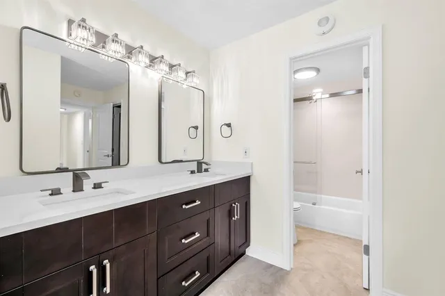 a bathroom with a toilet sink a shower and a mirror