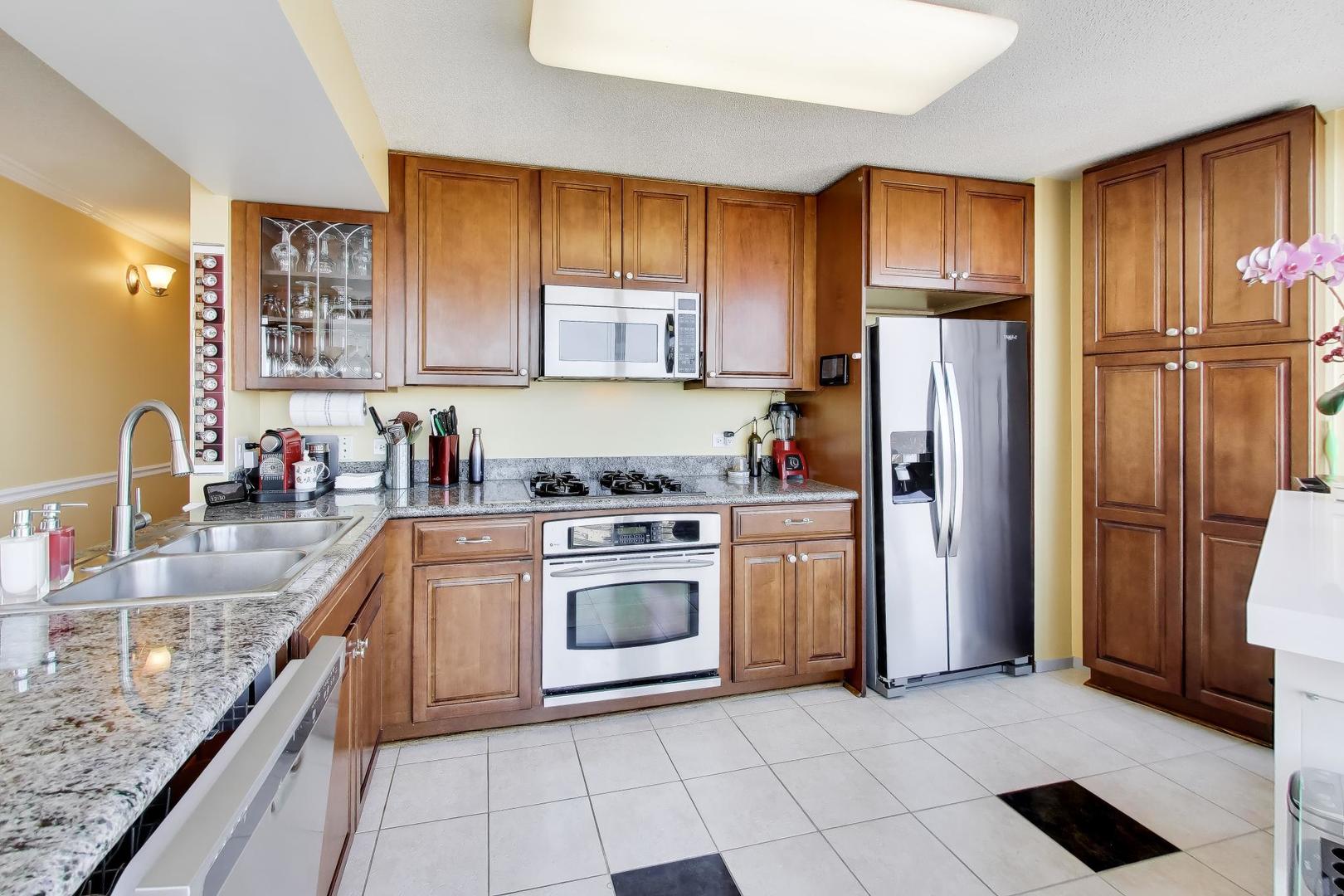 1720 Maple Avenue, Unit 2420 Evanston, IL 60201 - Photo 12 of 76 a kitchen with stainless steel appliances granite countertop a refrigerator sink and cabinets