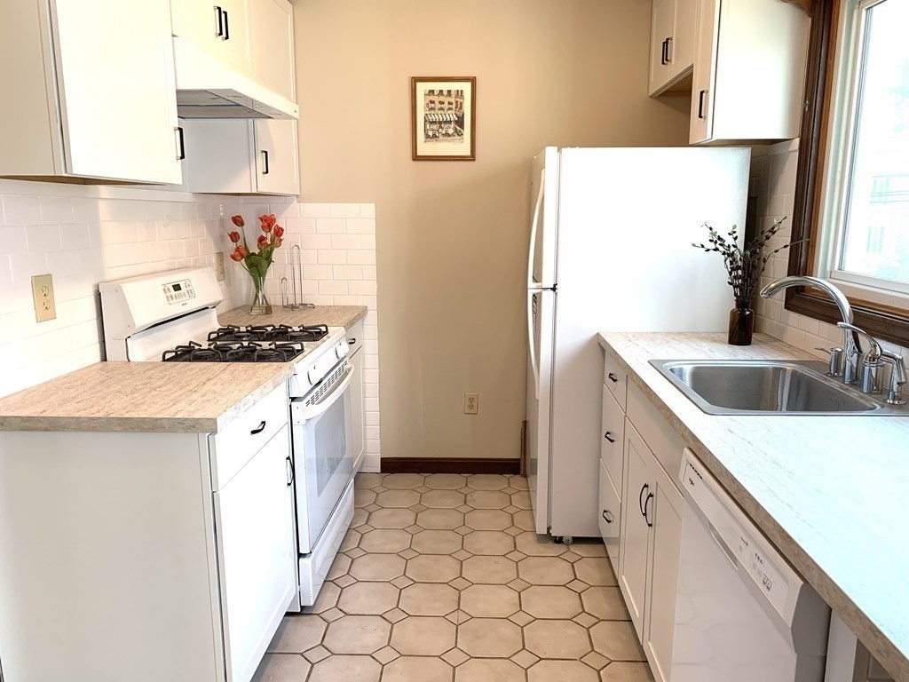 325 Mammoth Road, Unit 7 Lowell, MA 01854 - Photo 3 of 33 a kitchen with a sink a stove and refrigerator
