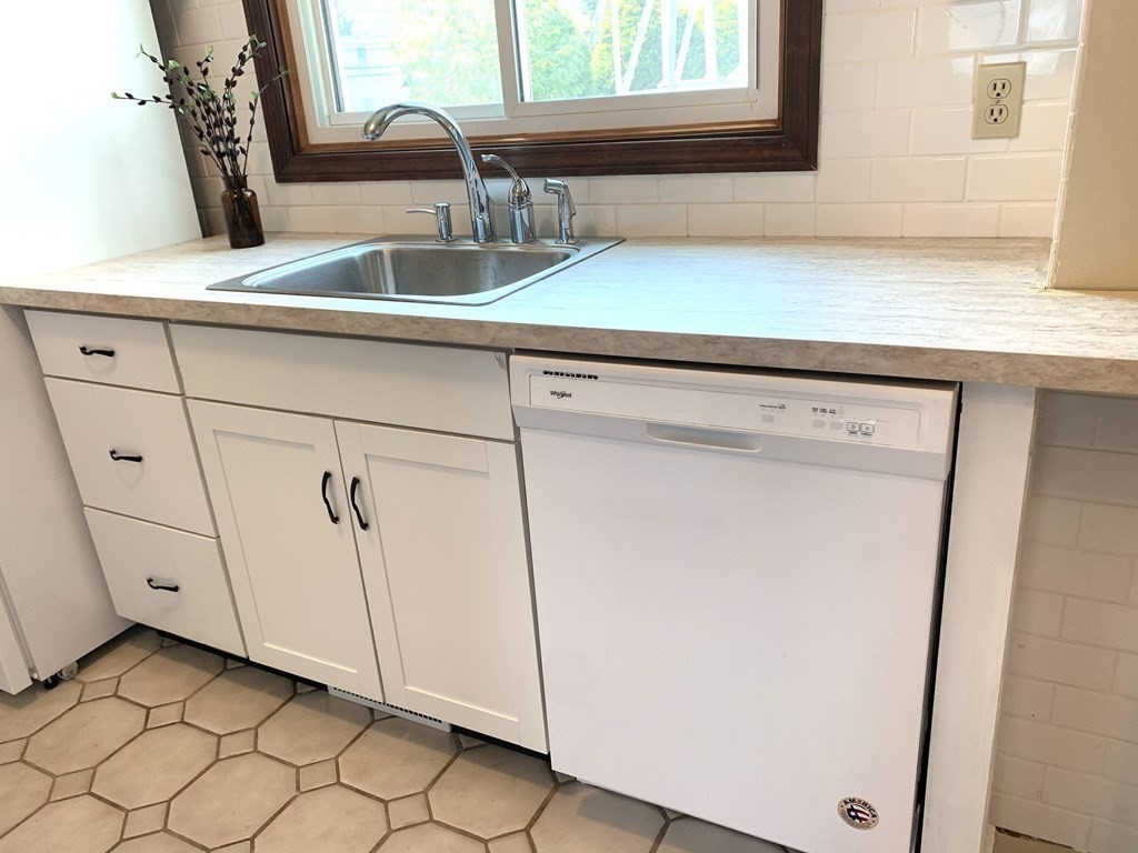 325 Mammoth Road, Unit 7 Lowell, MA 01854 - Photo 5 of 33 a kitchen with a sink and a mirror