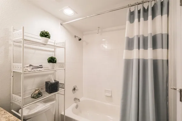 a front view of a building with glass windows and furniture