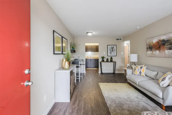 a living room with furniture and a wooden floor
