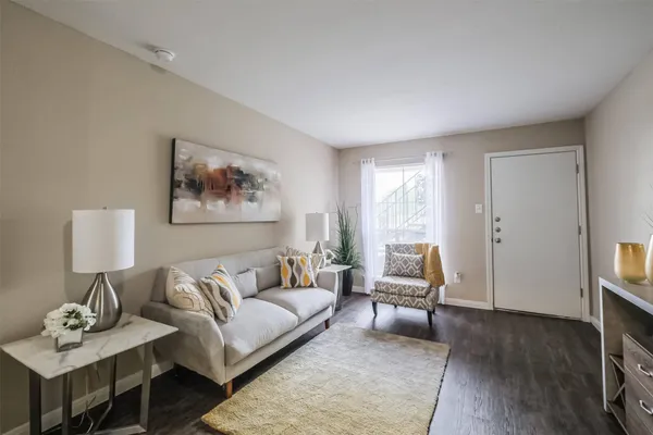 a living room with furniture and a wooden floor