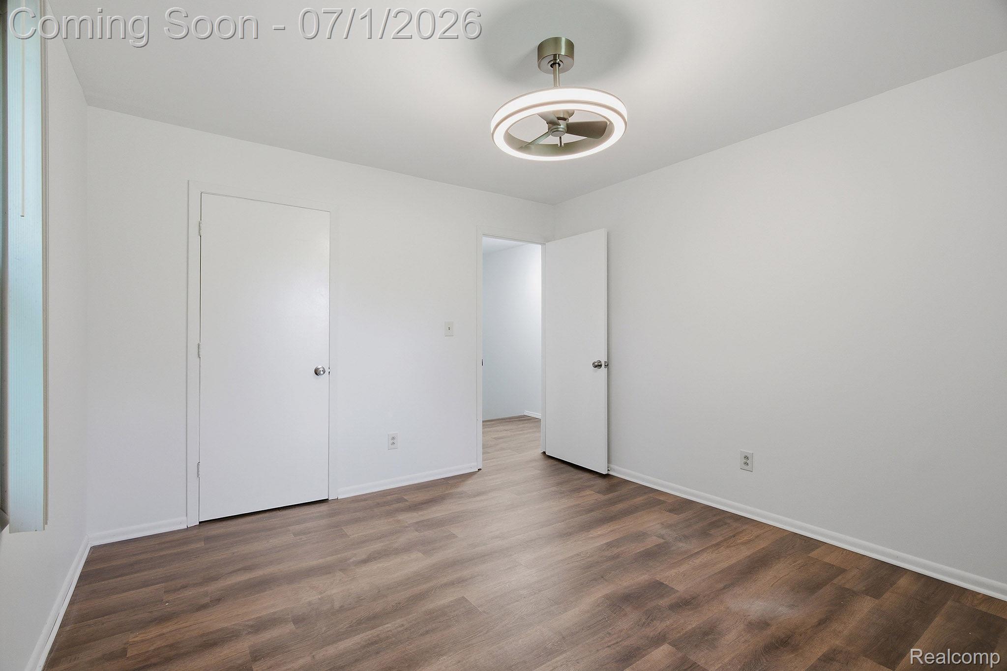 4762 Lonsberry Road Columbiaville, MI 48421 - Photo 17 of 36 Spacious room featuring wood-finish flooring, crisp white walls, a modern ceiling light fixture, and white trim