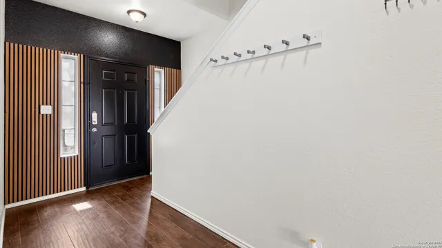 a view of kitchen with wooden floor electronic appliances and cabinets
