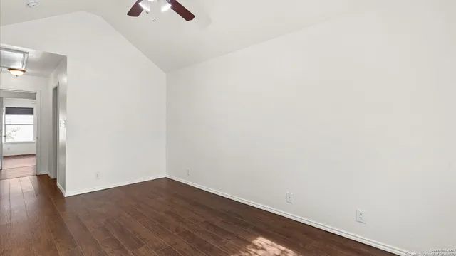 an empty room with a window and wooden floor