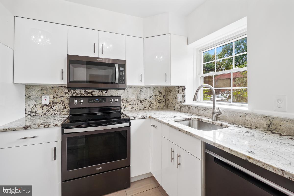 2134 Golf Course Drive Reston, VA 20191 - Photo 15 of 55 a kitchen with granite countertop a sink stove and microwave