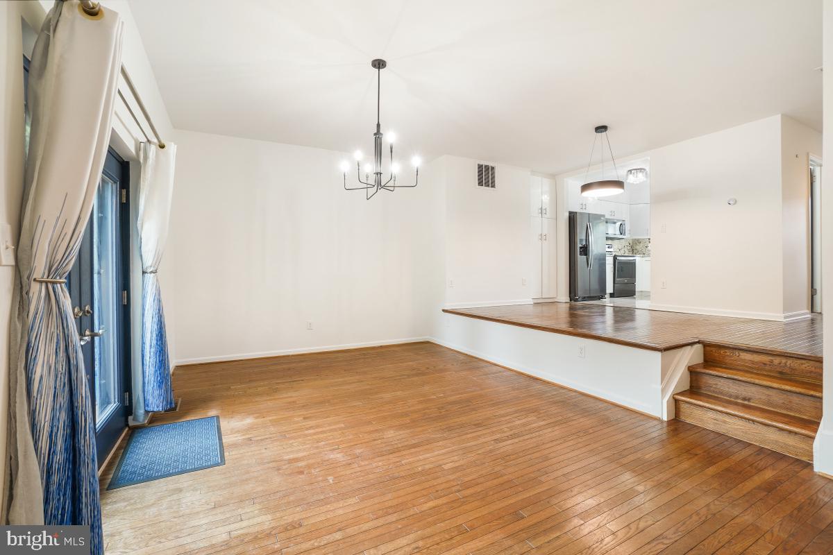 2134 Golf Course Drive Reston, VA 20191 - Photo 18 of 55 an empty room with wooden floor and chandelier