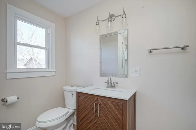 a bathroom with a sink toilet and mirror