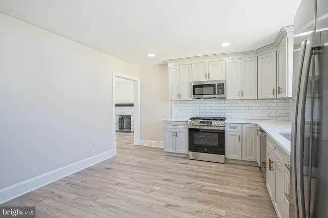 a kitchen with granite countertop a stove top oven and cabinets