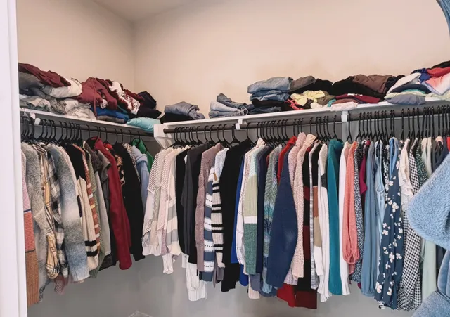 a view of walk in closet with clothes and shoes