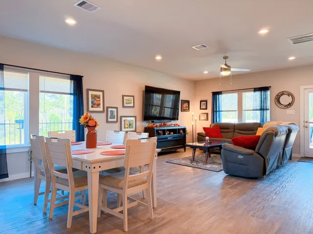 a living room with furniture a flat screen tv and wooden floor