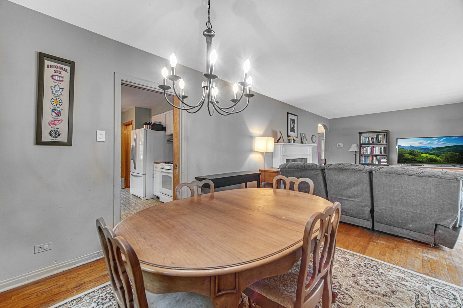 1644 West 187th Street Homewood, IL 60430 - Photo 8 of 24 a dining room with wooden floor a chandelier a wooden table and chairs