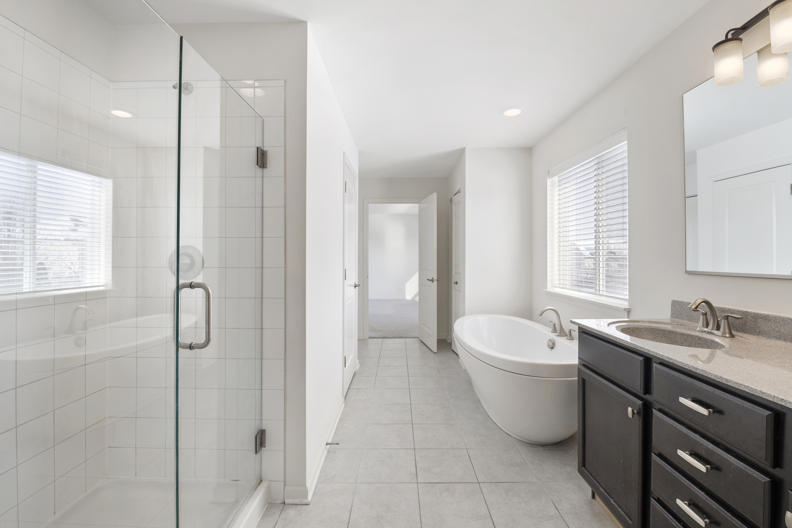 485 Stone Bluff Drive Romeoville, IL 60446 - Photo 21 of 35 a spacious bathroom with a double vanity sink a mirror and a bathtub