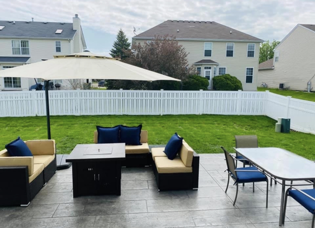 485 Stone Bluff Drive Romeoville, IL 60446 - Photo 32 of 35 a view of a patio with couches table and chairs under an umbrella