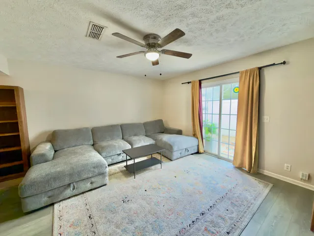 a living room with furniture and a ceiling fan