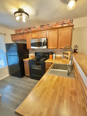 a kitchen with a sink a stove and a microwave