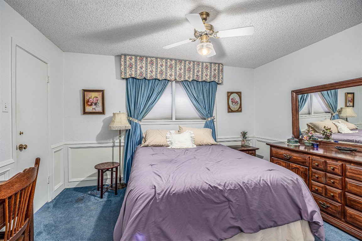 4613 Country Club View Baytown, TX 77521 - Photo 14 of 38 a bedroom with a bed a chandelier and a dresser