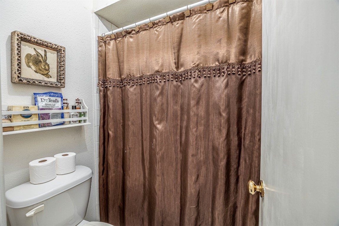 4613 Country Club View Baytown, TX 77521 - Photo 16 of 38 a bathroom with a shower curtain and a toilet
