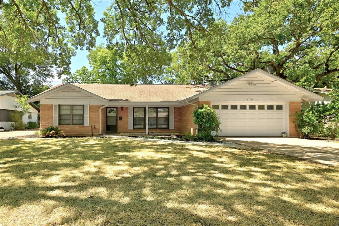 1709 Rogge Lane Austin, TX 78723 - Photo 1 of 1 a front view of a house with a garden