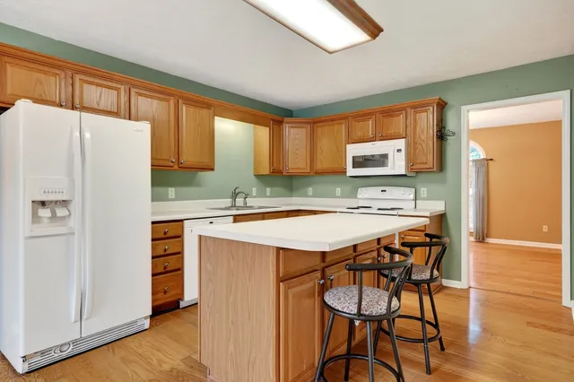 a kitchen with stainless steel appliances granite countertop a stove a sink dishwasher and a refrigerator