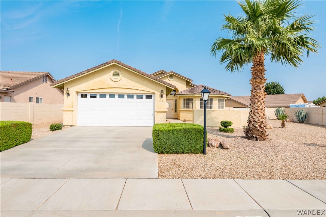4305 East Cane Ranch Road Kingman, AZ 86401 - Photo 1 of 38 a front view of a house with a garden