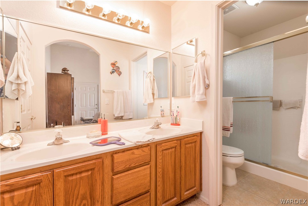 4305 East Cane Ranch Road Kingman, AZ 86401 - Photo 17 of 38 a bathroom with a double vanity sink toilet and a mirror