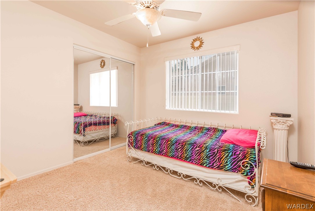 4305 East Cane Ranch Road Kingman, AZ 86401 - Photo 19 of 38 a bedroom with a bed and a chandelier
