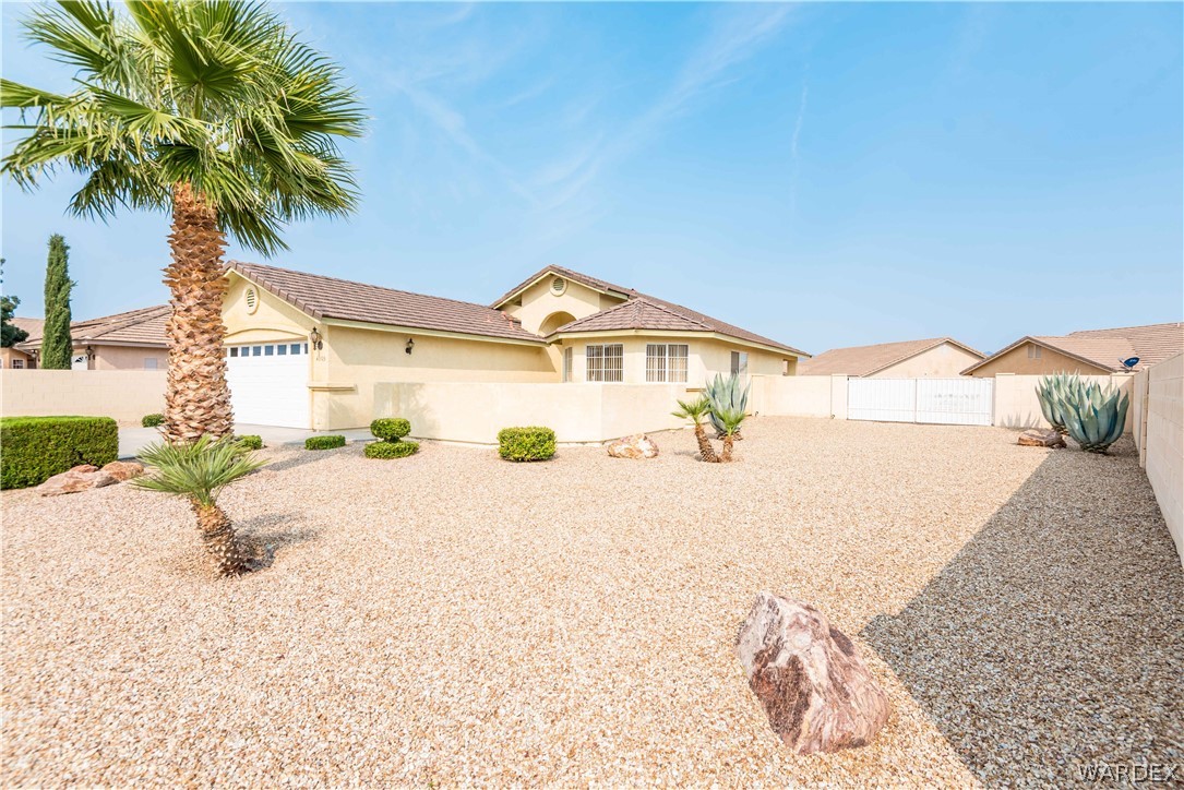 4305 East Cane Ranch Road Kingman, AZ 86401 - Photo 2 of 38 a front view of a house with a yard and a garage